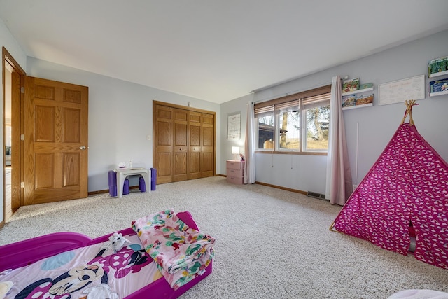 bedroom with carpet floors, a closet, visible vents, and baseboards