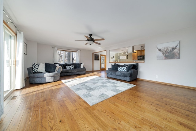 unfurnished living room featuring light wood-type flooring, visible vents, and baseboards