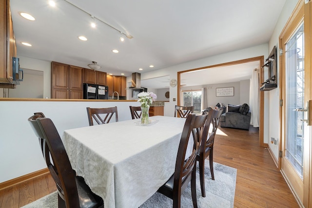 dining room featuring baseboards, light wood finished floors, track lighting, and recessed lighting