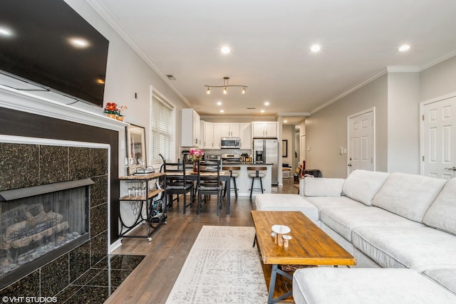 living room featuring crown molding, dark wood finished floors, recessed lighting, visible vents, and a tiled fireplace