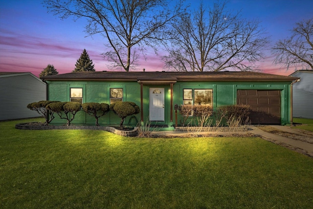 view of front facade featuring a garage, driveway, a front lawn, and stucco siding