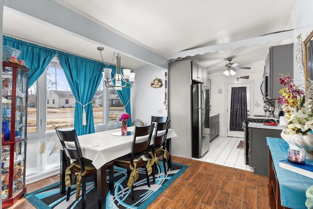 dining space with light wood-style flooring and ceiling fan with notable chandelier