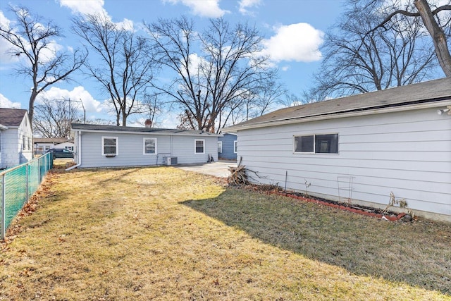 rear view of house with a patio area, a lawn, central AC unit, and fence