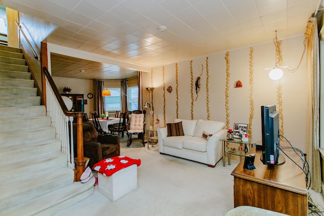 carpeted living area featuring stairs