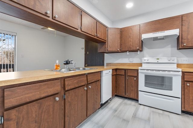 kitchen featuring white appliances, a sink, and under cabinet range hood