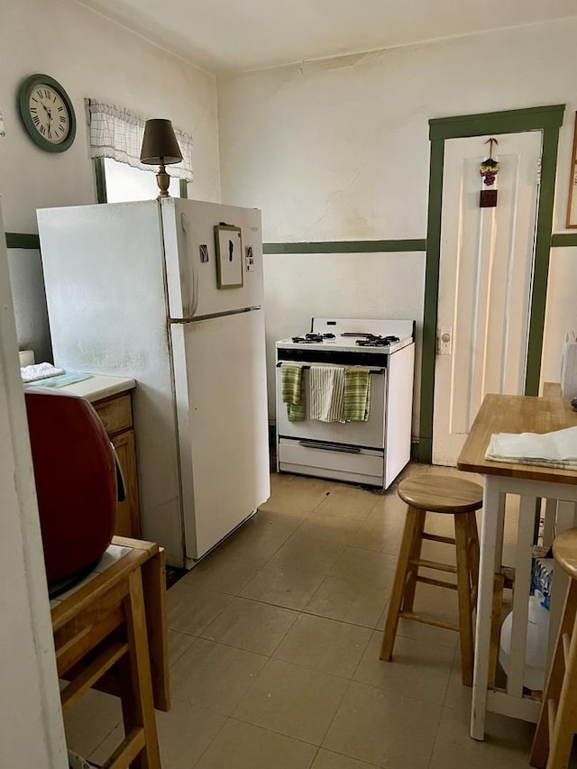 kitchen featuring white appliances and tile patterned floors