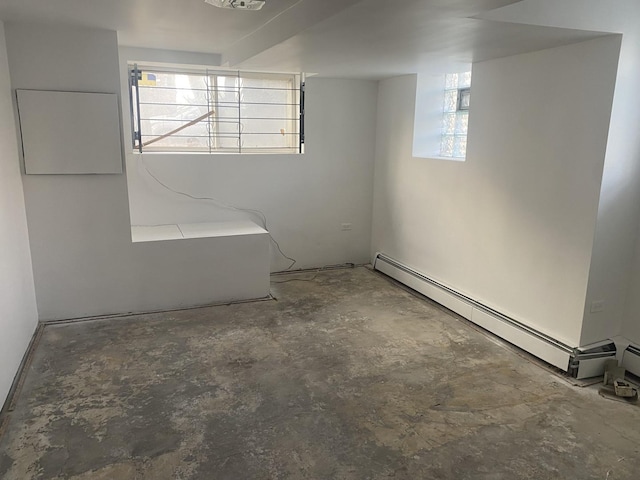 basement featuring a wealth of natural light and baseboard heating