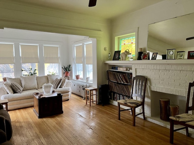 interior space featuring ornamental molding, a ceiling fan, hardwood / wood-style flooring, and radiator