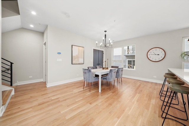 dining area with baseboards, a notable chandelier, light wood-style flooring, and stairs