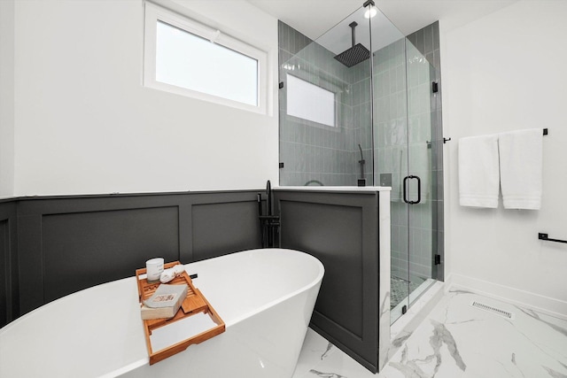 bathroom featuring a wainscoted wall, marble finish floor, a shower stall, a decorative wall, and a soaking tub