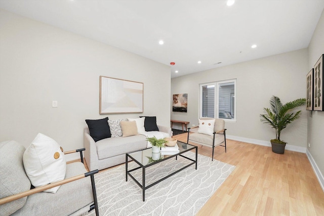 living room with recessed lighting, light wood-style flooring, and baseboards