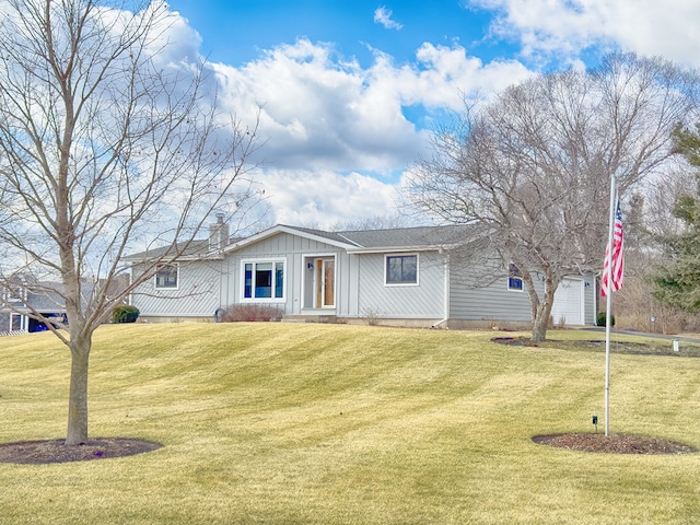 single story home with an attached garage, a chimney, a front lawn, and board and batten siding