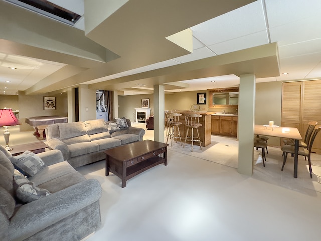 living room with finished concrete flooring, pool table, and bar