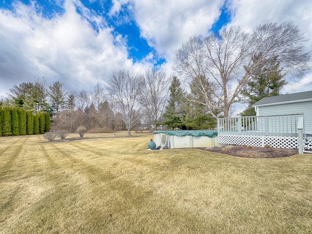 view of yard featuring a covered pool and a deck