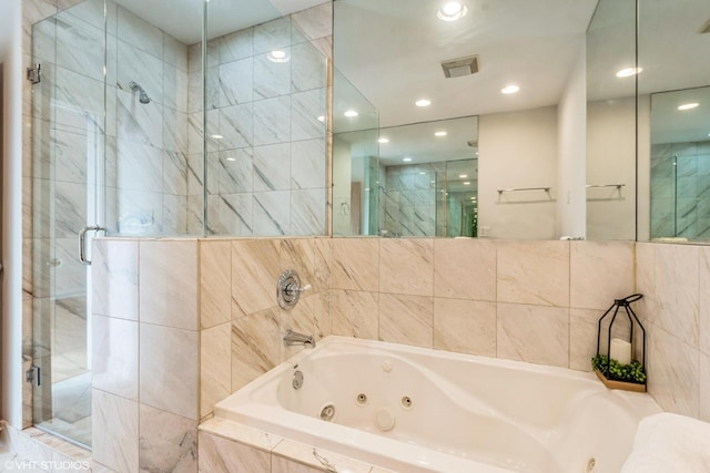 full bathroom with visible vents, a stall shower, a whirlpool tub, and tile walls