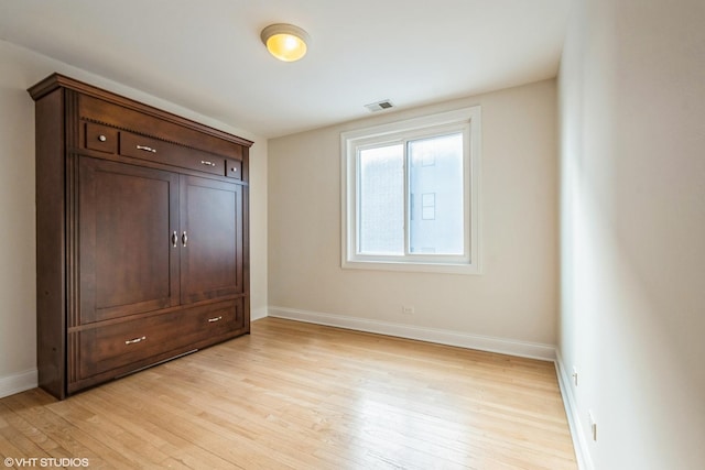 unfurnished bedroom with baseboards, visible vents, and light wood-style floors