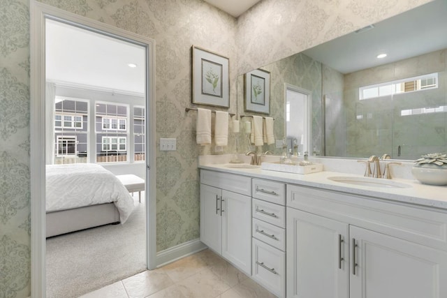 full bathroom featuring double vanity, wallpapered walls, baseboards, and a sink