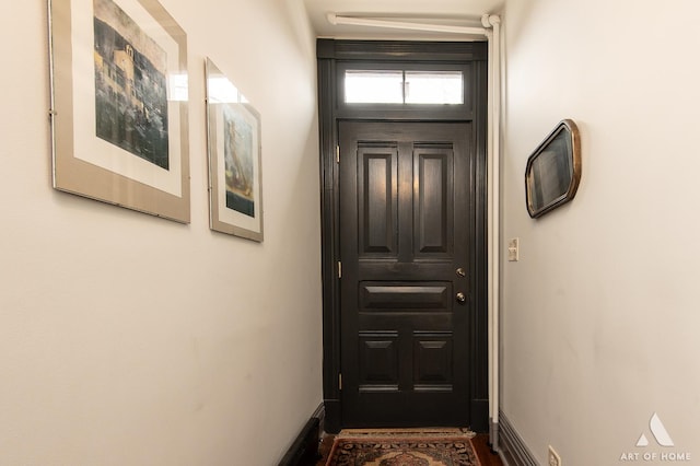 doorway featuring baseboards