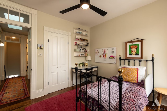 bedroom with baseboards, a closet, ceiling fan, and wood finished floors