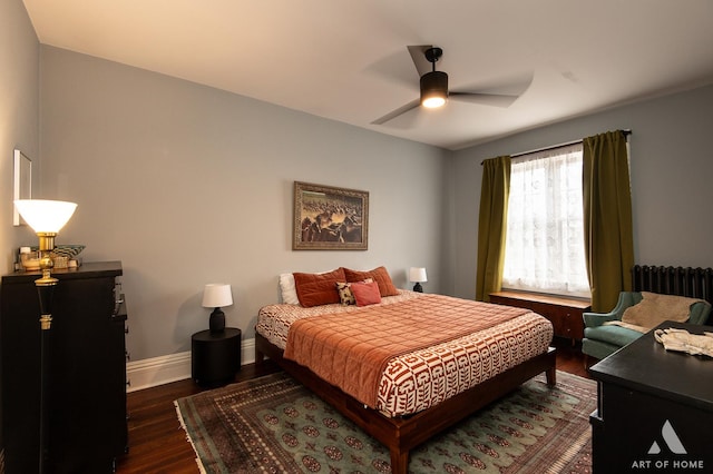 bedroom featuring radiator, ceiling fan, baseboards, and dark wood-type flooring
