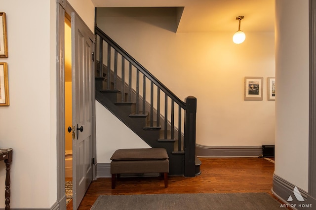 staircase with baseboards and wood finished floors