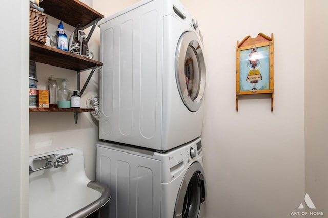 washroom with stacked washer and clothes dryer and laundry area