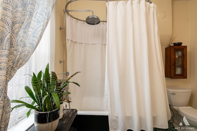 full bathroom featuring a shower with curtain and toilet