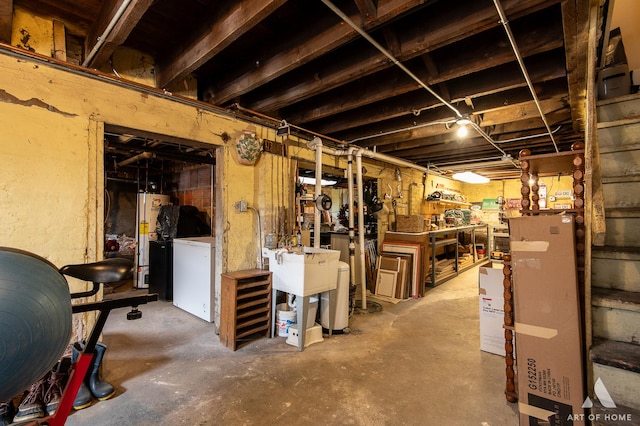 unfinished below grade area featuring a workshop area, refrigerator, and gas water heater