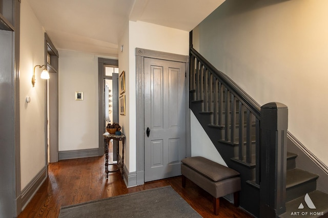 stairway featuring baseboards and wood finished floors