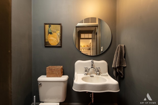 half bathroom featuring toilet and a sink