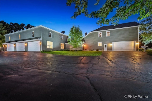 view of front facade featuring driveway, an attached garage, fence, and a front yard