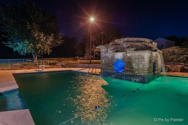 pool at twilight with fence and a fenced in pool