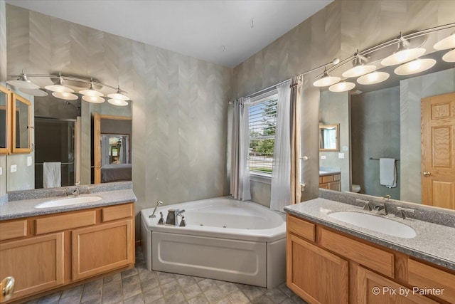 full bathroom featuring a jetted tub, a shower stall, two vanities, and a sink