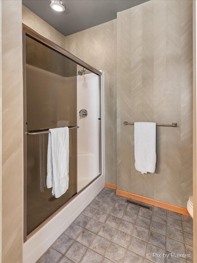 full bathroom with toilet, a shower stall, and visible vents