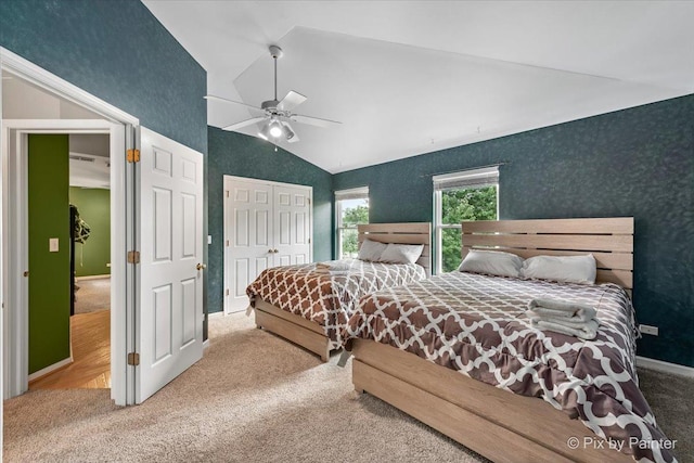 carpeted bedroom featuring wallpapered walls, ceiling fan, high vaulted ceiling, and a closet