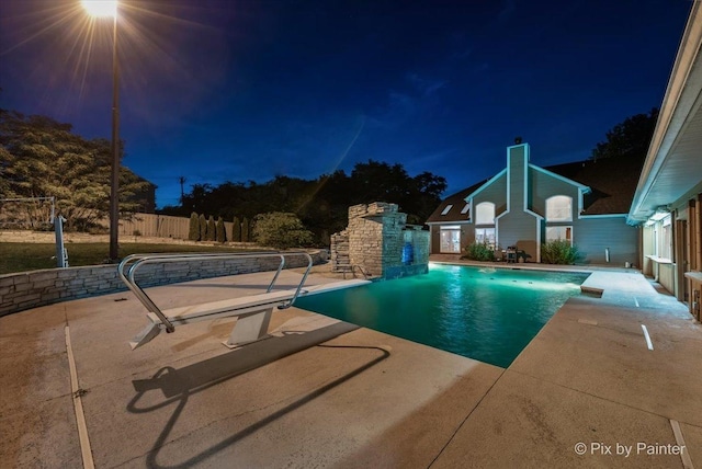 pool at twilight with a patio, fence, and an outdoor pool