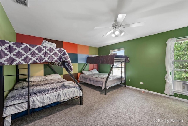 carpeted bedroom with a ceiling fan, visible vents, and baseboards