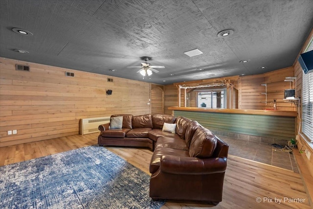 living room featuring radiator, visible vents, and wood finished floors