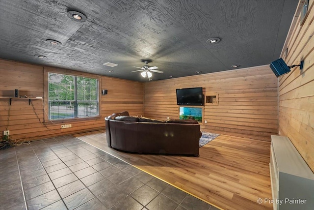 tiled living area with a ceiling fan, wood walls, visible vents, and recessed lighting