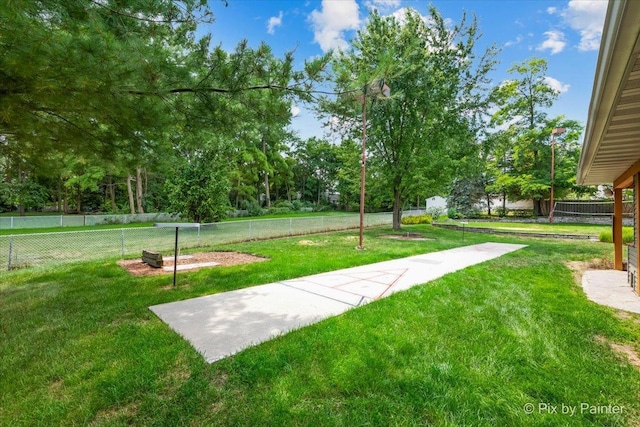 view of community with a yard and a fenced backyard