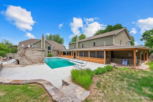 view of swimming pool with a sunroom, fence, a fenced in pool, and a patio