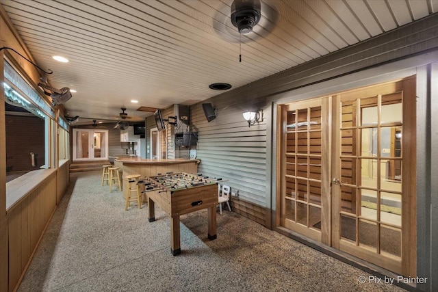 recreation room featuring carpet, wooden ceiling, and ceiling fan