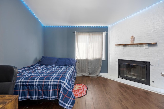 bedroom featuring a fireplace and wood finished floors