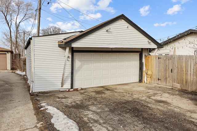 detached garage featuring fence