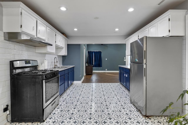 kitchen featuring appliances with stainless steel finishes, under cabinet range hood, blue cabinetry, white cabinetry, and a sink