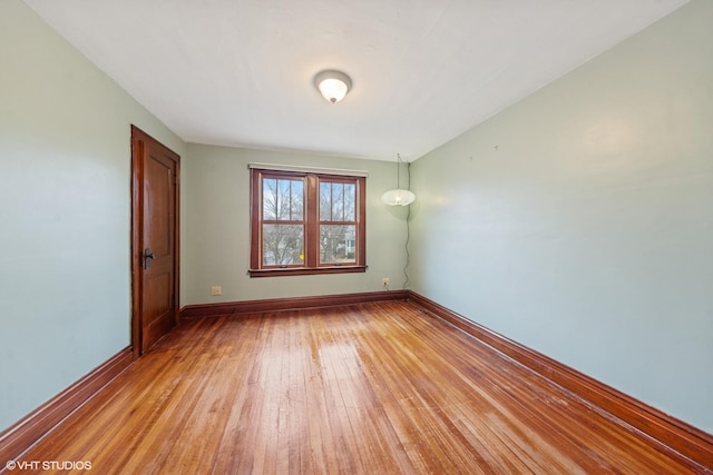 empty room with baseboards and light wood-style floors