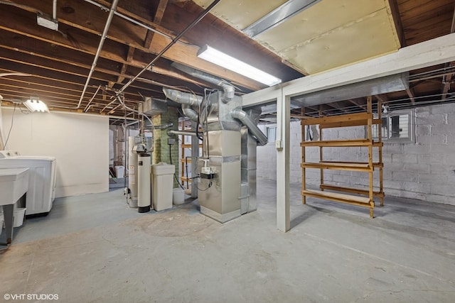 unfinished basement with water heater, heating unit, and washer and dryer