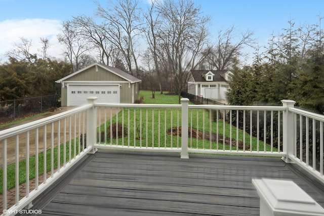 deck featuring a lawn, an outdoor structure, fence, and a detached garage