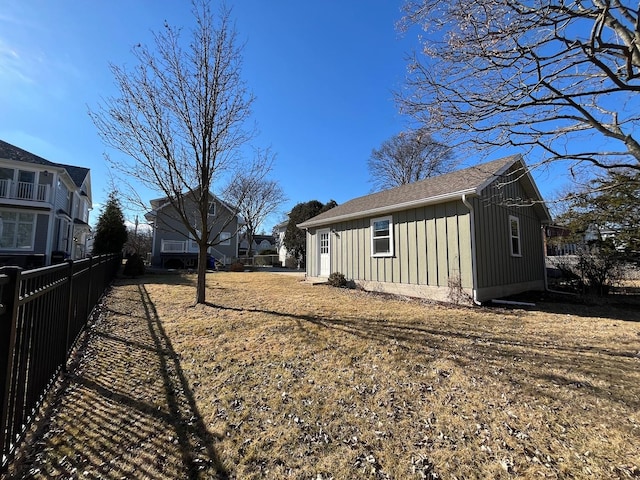 view of side of property with board and batten siding and fence