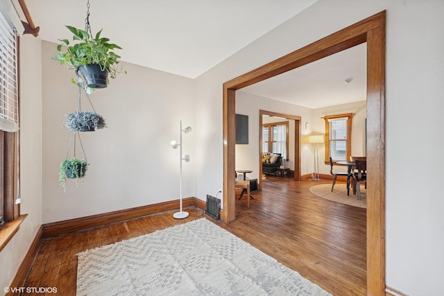 foyer entrance featuring baseboards and wood finished floors